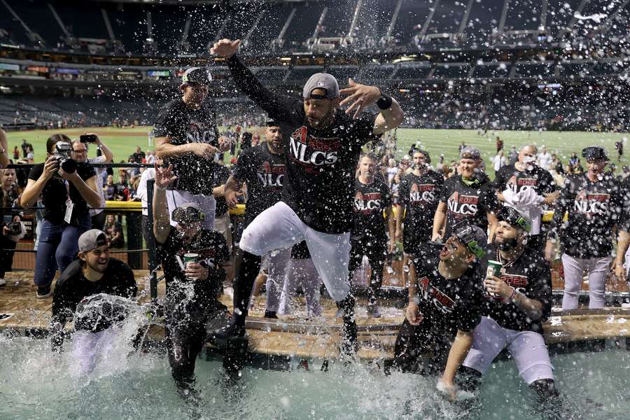 Spelers van de D-backs springen in het zwembad om de overwinning te vieren