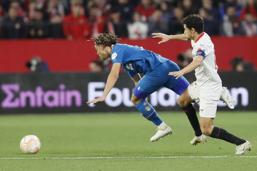 Sevilla-speler Jesus Navas in actie tegen  Xavi Simons van PSV