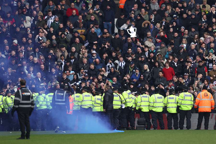 Police line the edge of the pitch after trouble breaks out between fans during the FA Cup fourth round football match between West Brom and Wolves