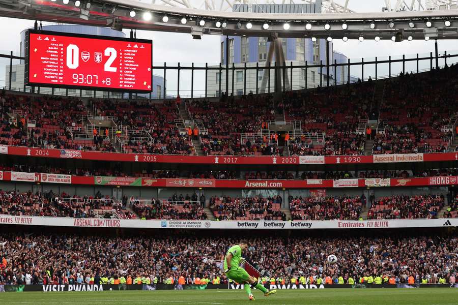 Aston Villa's Argentinian goalkeeper #01 Emiliano Martinez takes a kick as the scoreboard displays the final scoreline