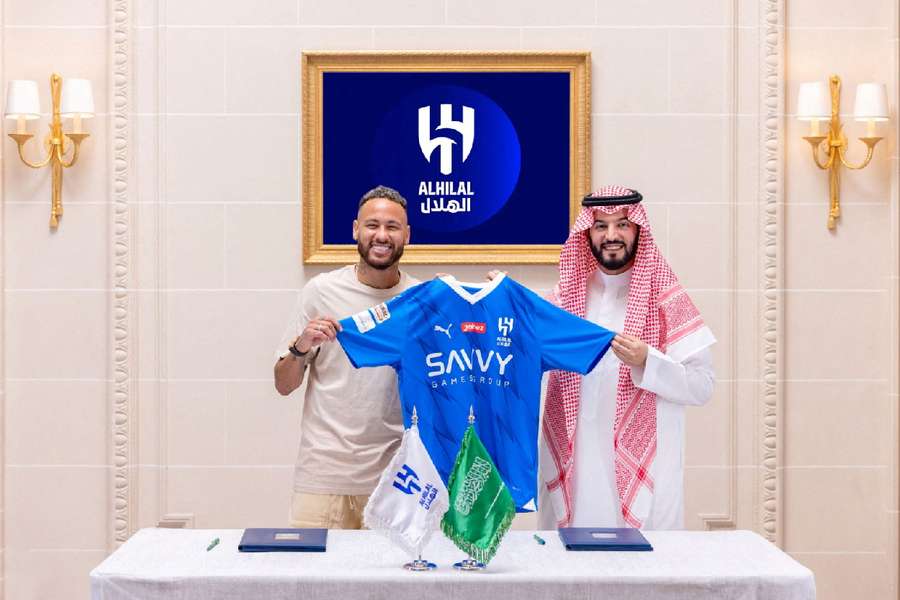 Al Hilal's new signing Neymar holds their shirt as he poses with President Fahd bin Saad Al-Nafel