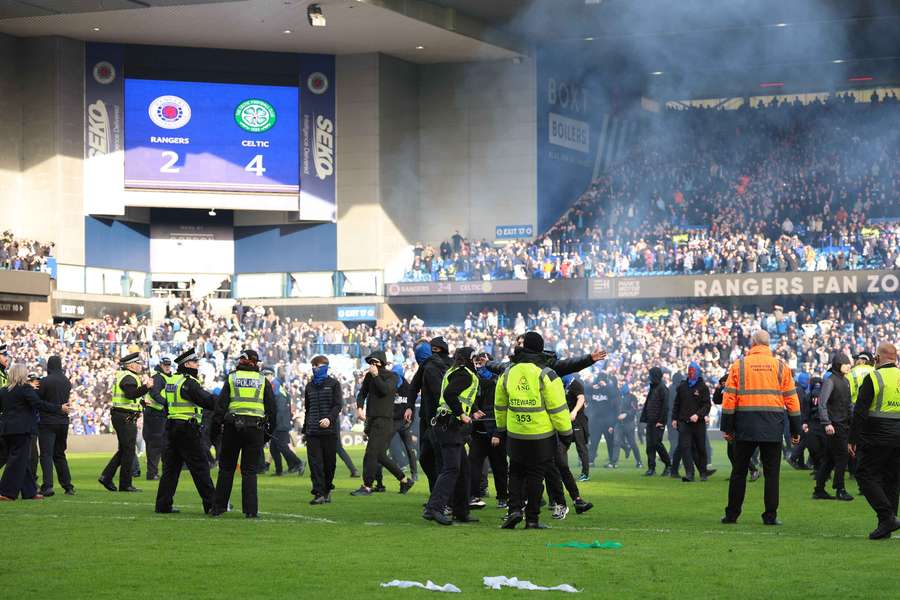 Rangers fans clash with police on the pitch after the match