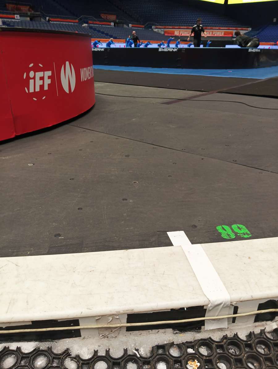 Vykukující led v ostravské hale, za ním trénink národního týmu.