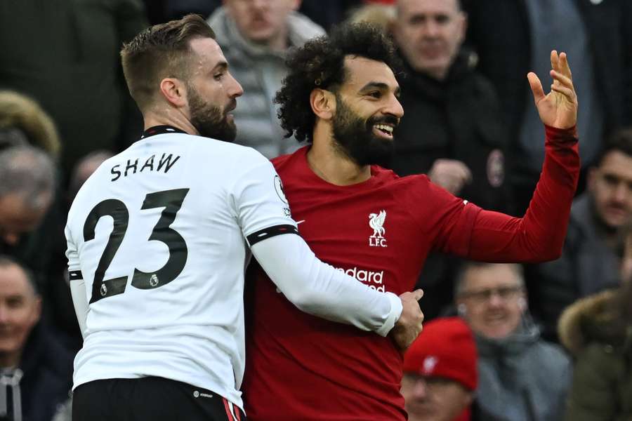 Luke Shaw em disputa com Mohamed Salah neste domingo (5) em Anfield Road