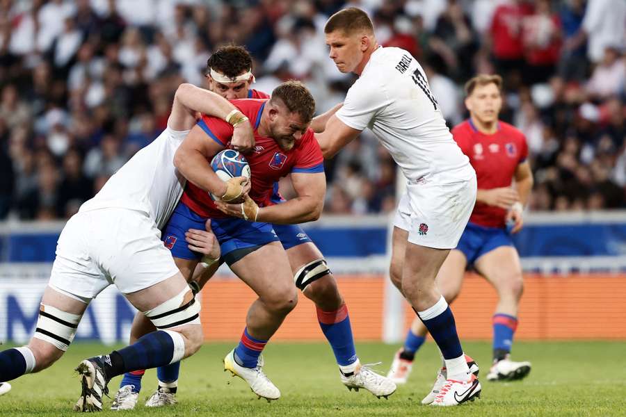 England's lock Ollie Chessum (L) and England's fly-half Owen Farrell (R) tackle Chile's hooker Tomas Dussaillant (C)