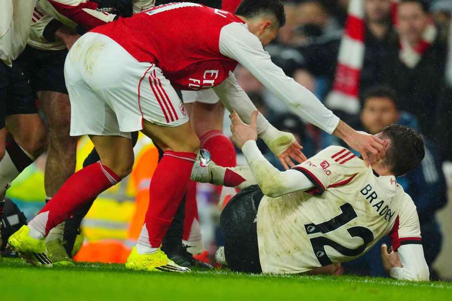 Martinelli próbuje zepchnąć kontuzjowanego Bradleya.