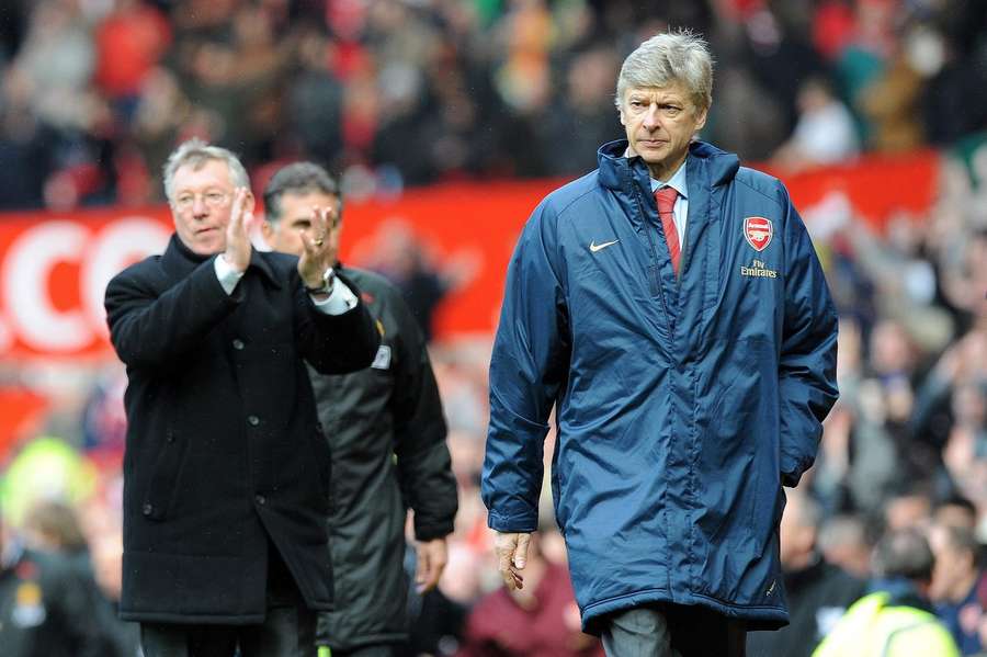 Manchester United-manager Sir Alex Ferguson (tv.) klapper, mens Arsenal-manager Arsene Wenger går nedtrykt derfra.