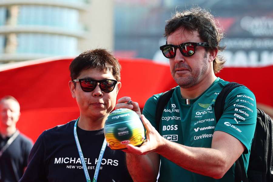 Fernando Alonso firma un minicasco a un fan Fernando Alonso firma un minicasco a un fan