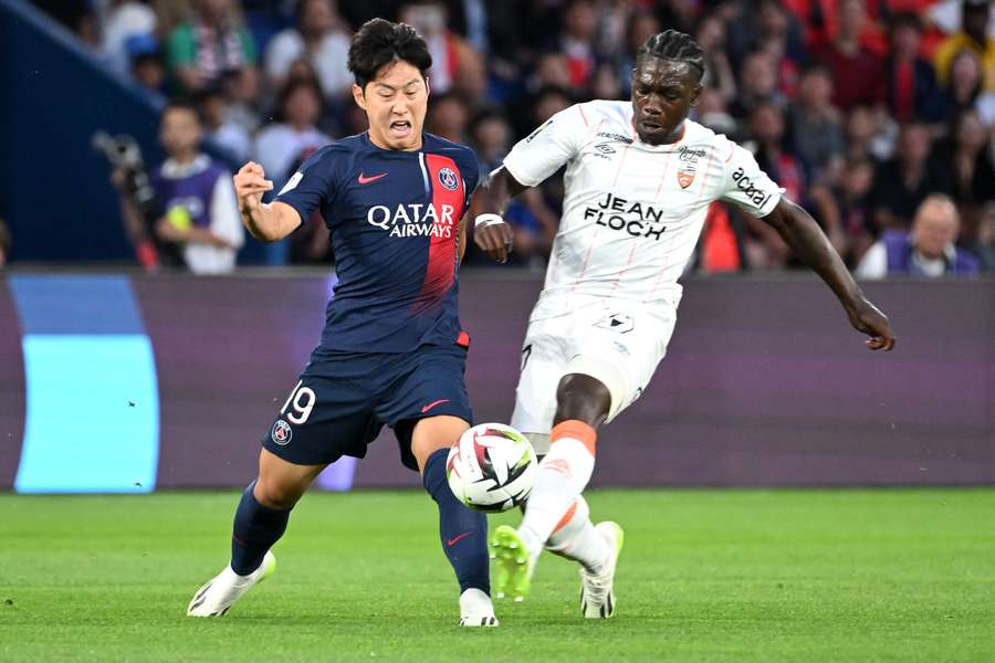 Le milieu lorientais Jean-Victor Makengo dispute le ballon avec le Parisien Lee Kang-in lors du match de Ligue 1 entre le PSG et Lorient, le 12 août 2023 au Parc des Princes.