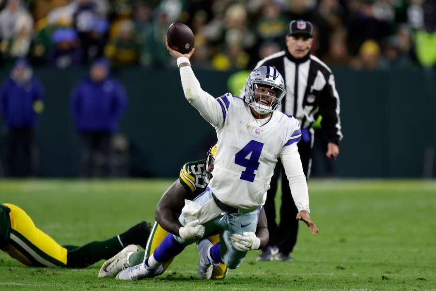 Dallas Cowboys quarterback Dak Prescott wordt tegen de grond gewerkt door Jarran Reed van de Green Bay Packers