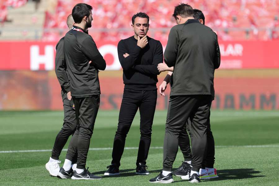 Barcelona's Spanish coach Xavi talks with his technical staff