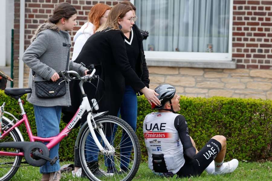 Tim Wellens zit met pijn in het gras na de crash