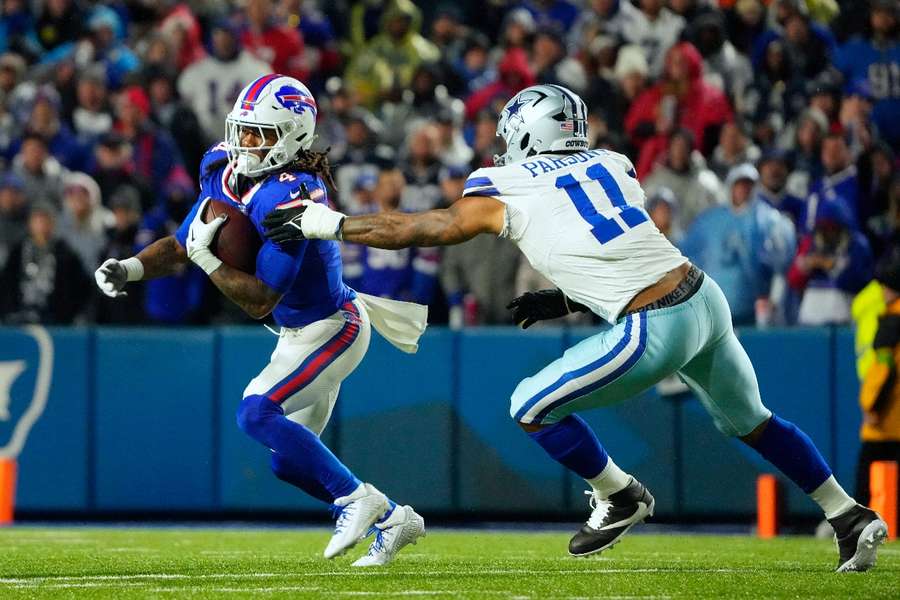 Il running back dei Buffalo Bills James Cook corre la palla sotto la pressione del linebacker dei Dallas Cowboys Micah Parsons.