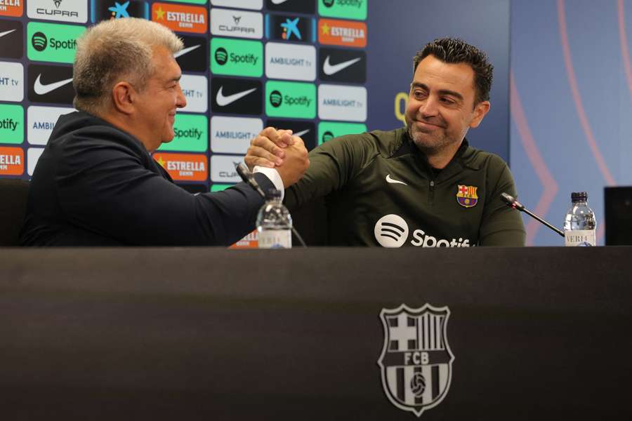 Joan Laporta (L) en Xavi tijdens de persconferentie op donderdagmiddag