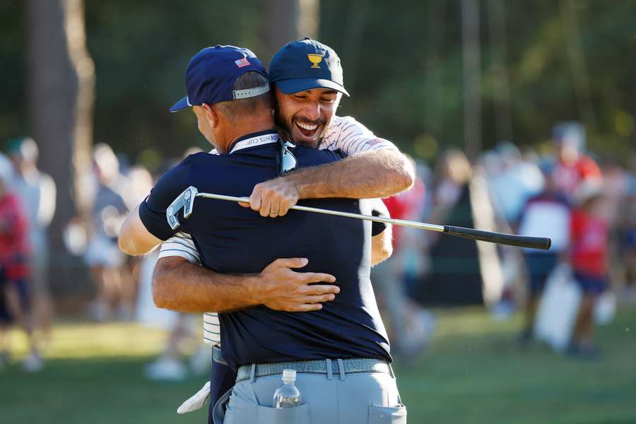 Max Homa (R) celebrates with instructor Mark Blackburn after making his putt on the 18th green during Friday four-ball matches.