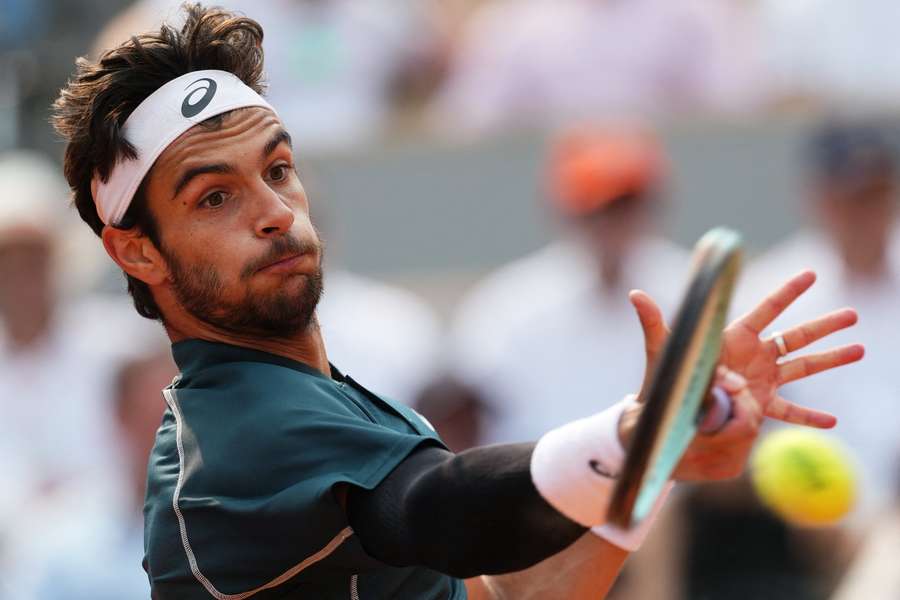 Lorenzo Musetti plays a forehand return to Frances Tiafoe 