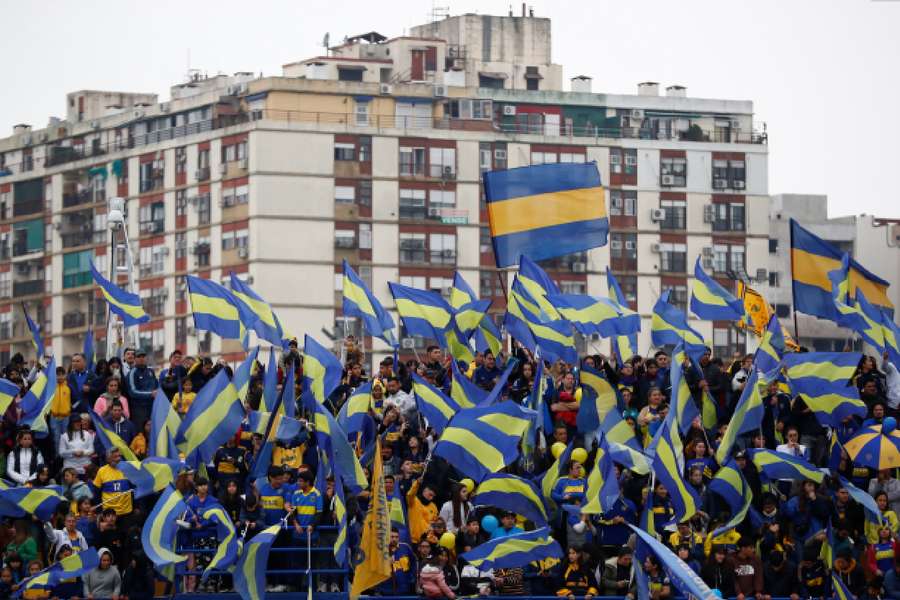 Boca Juniors fans cheer and wave flags during a women's soccer match against Gimnasia La Plata