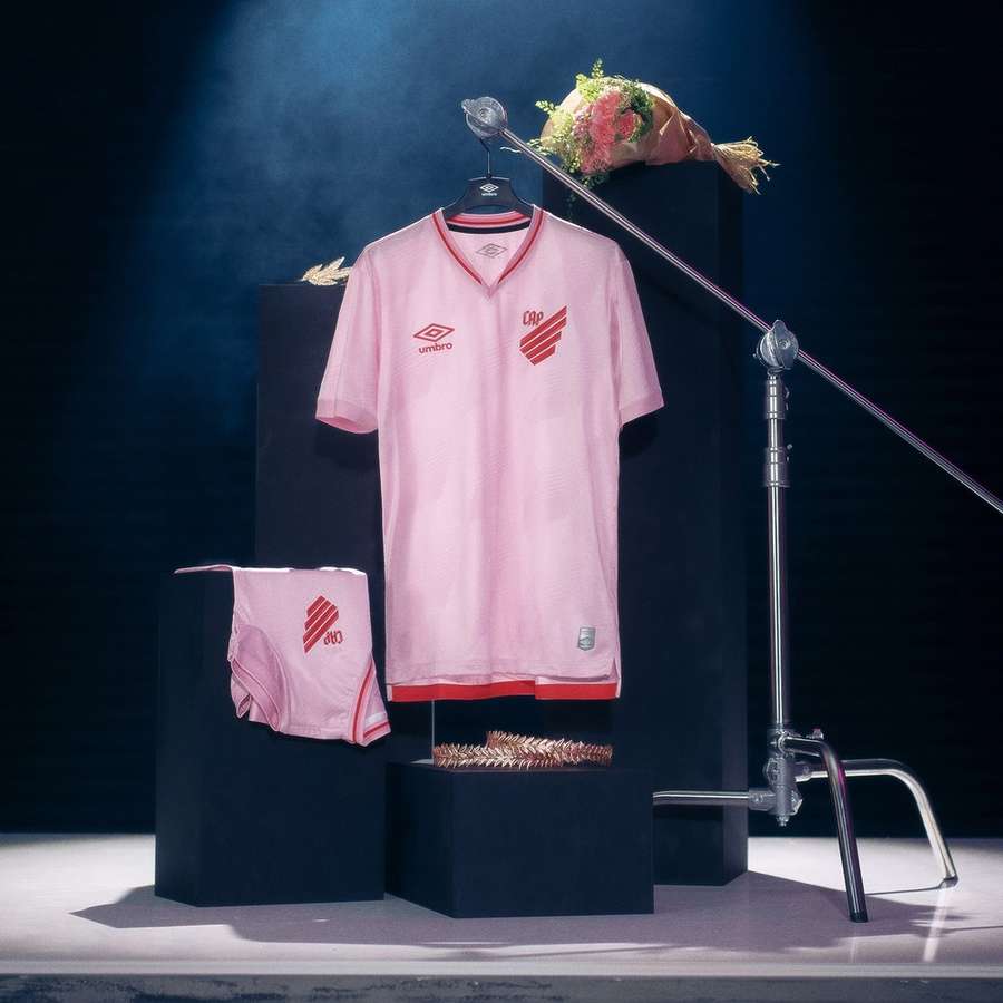 Camisa traz predominância da cor rosa e a gola em V