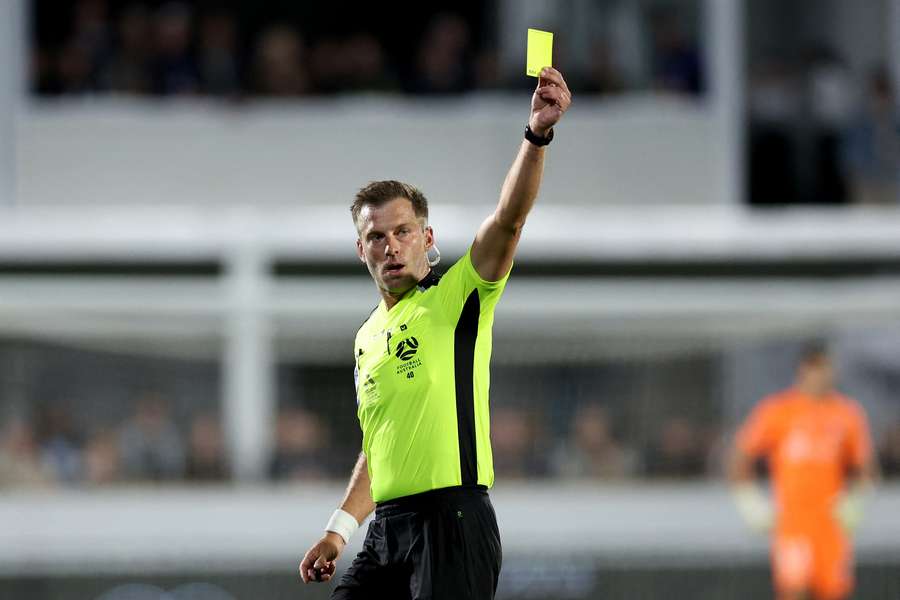 Referee Alex King shows a yellow card during the 2025-26 A-League Men Grand Final.