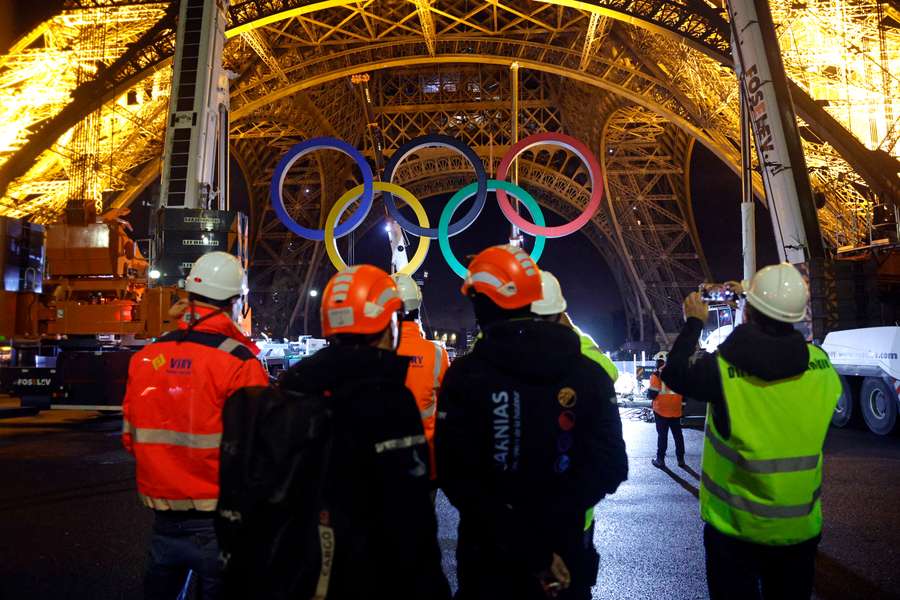 Cranes remove the Olympic rings from the Eiffel Tower in Paris