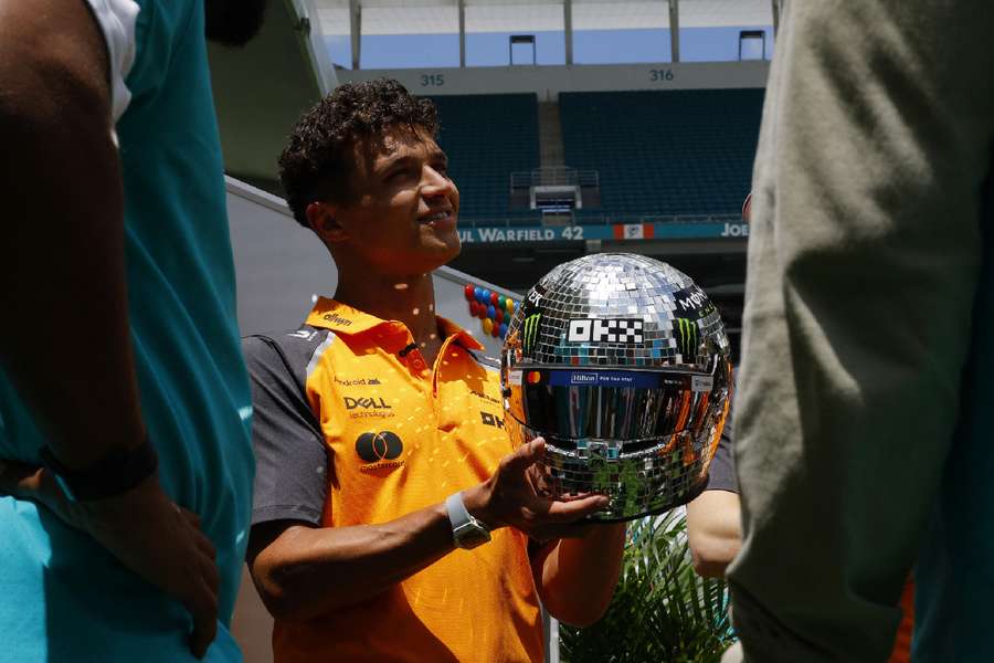 Norris holds his special helmet