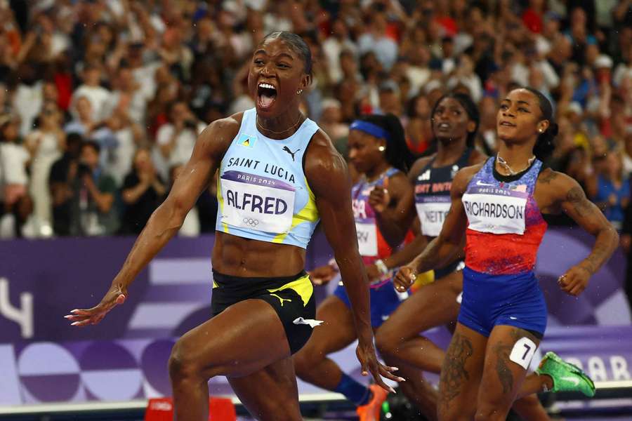 Julien Alfred of Saint Lucia celebrates after crossing the finish line to win gold