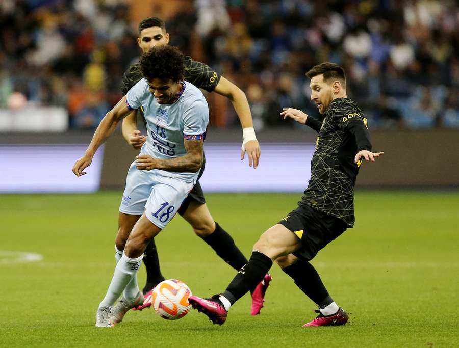 Paris St Germain's Lionel Messi in action with Saudi Pro League XI's Luiz Gustavo