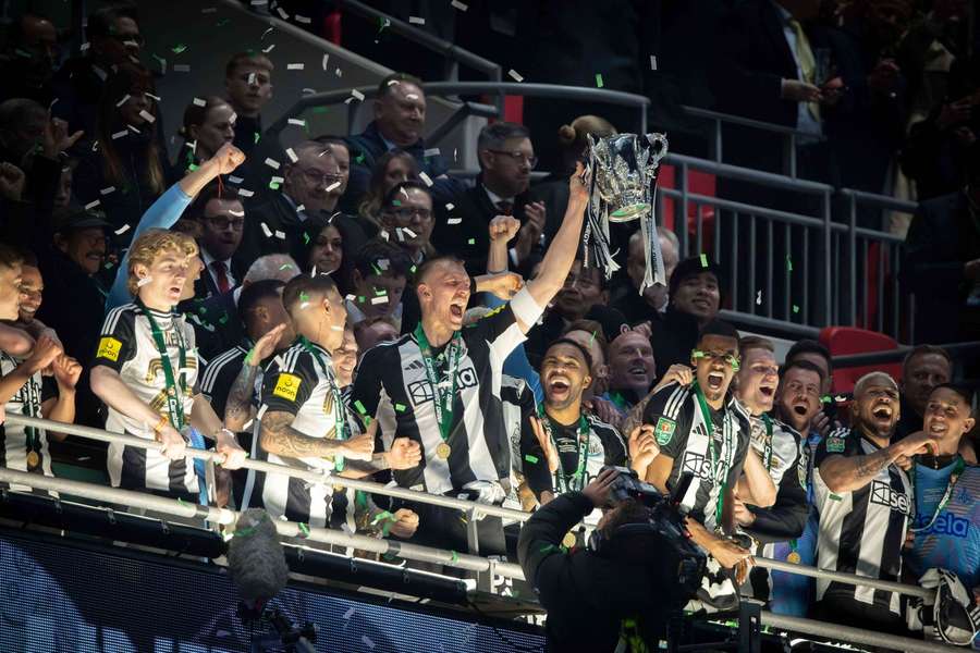 Dan Burn of Newcastle United lifts the Carabao Cup trophy at Wembley