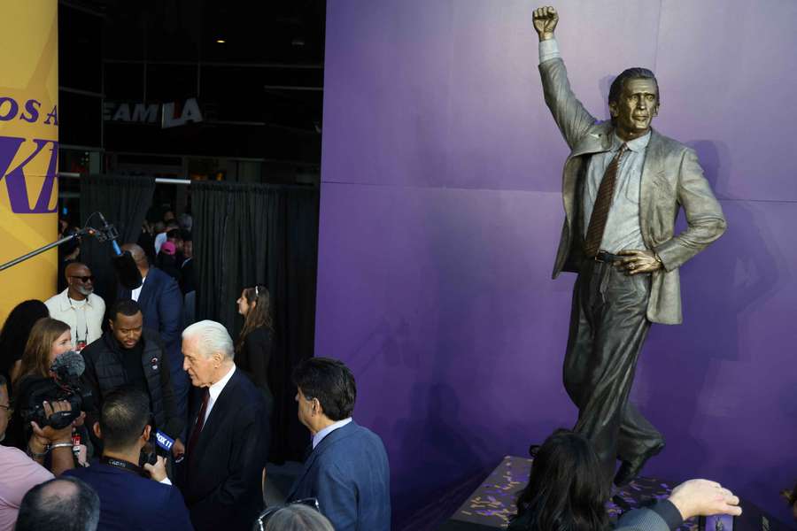 Pat Riley (white hair) next to his statue