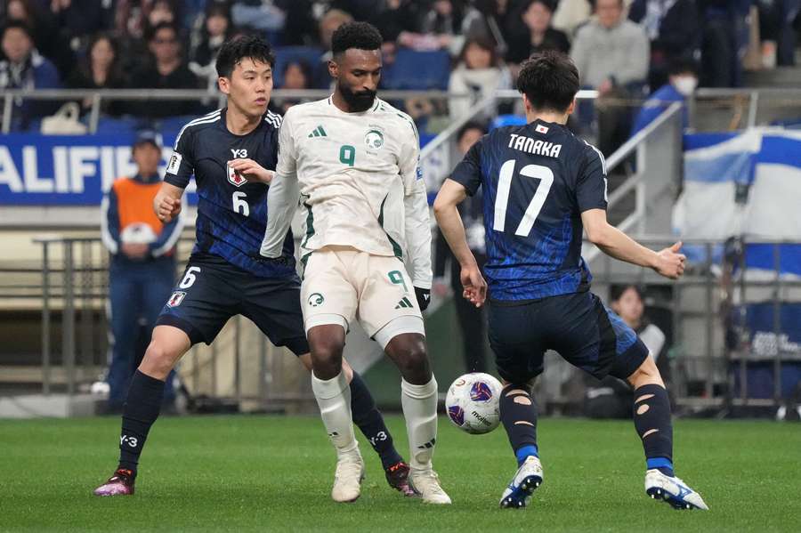 Feras Albrikan of Saudi Arabia (centre) controls the ball against Wataru Endo of Japan (left) during the FIFA World Cup qualifier