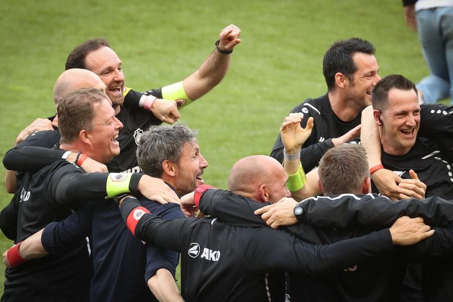 Mark van Bommel viert feest met zijn Antwerp-collega's na het winnen van de finale