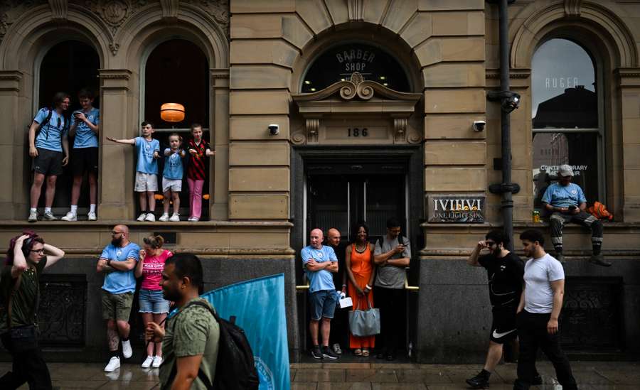 Supporters take shelter from the rain