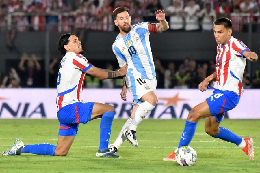 Messi tenta escapar da oposição de dois adversários