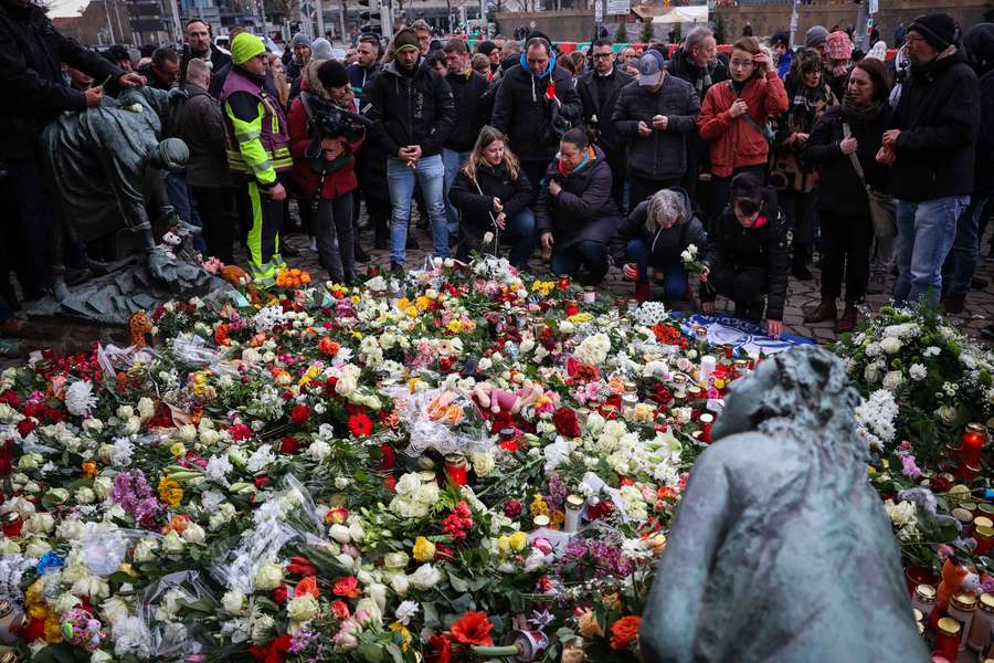 Mourners lay flowers near the site of a car-ramming attack on a Christmas market in Magdeburg