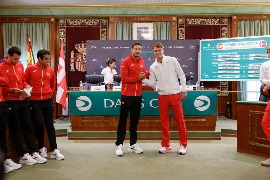 Pablo Carreno shakes hands with his Holger Rune as they attend a press conference in Marbella