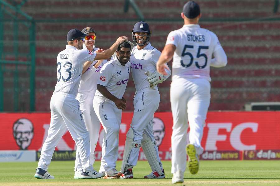 Rehan Ahmed (C) celebrates with his England teammates after taking a wicket