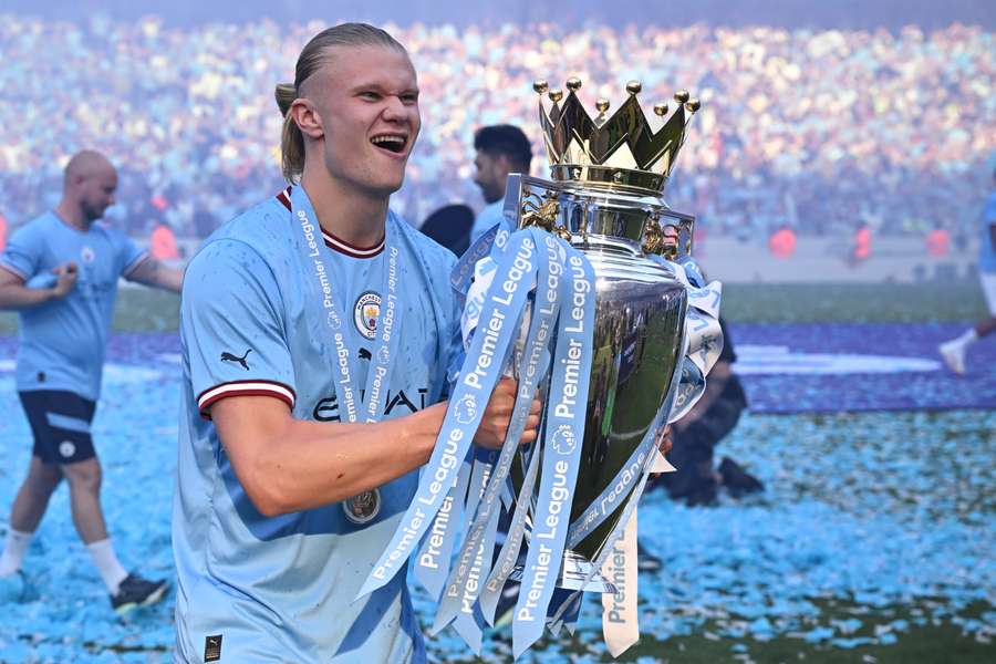 O atacante norueguês Erling Haaland, do Manchester City, posa com o troféu da Premier League no gramado