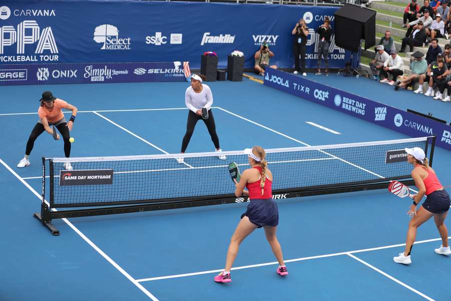 Irina Tereschenko bate uma bola de dink contra uma jogada da final de pares femininos