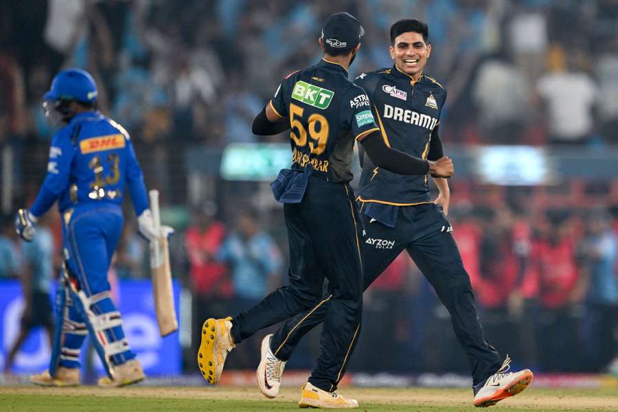 Gujarat Titans' captain Shubman Gill (R) celebrates with his teammate after winning the match