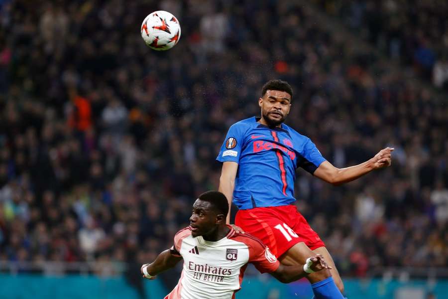 Malcom Edjouma, în duel cu Moussa Niakhate, în timpul partidei din Europa League dintre FCSB și Lyon, sezonul 2024/2025