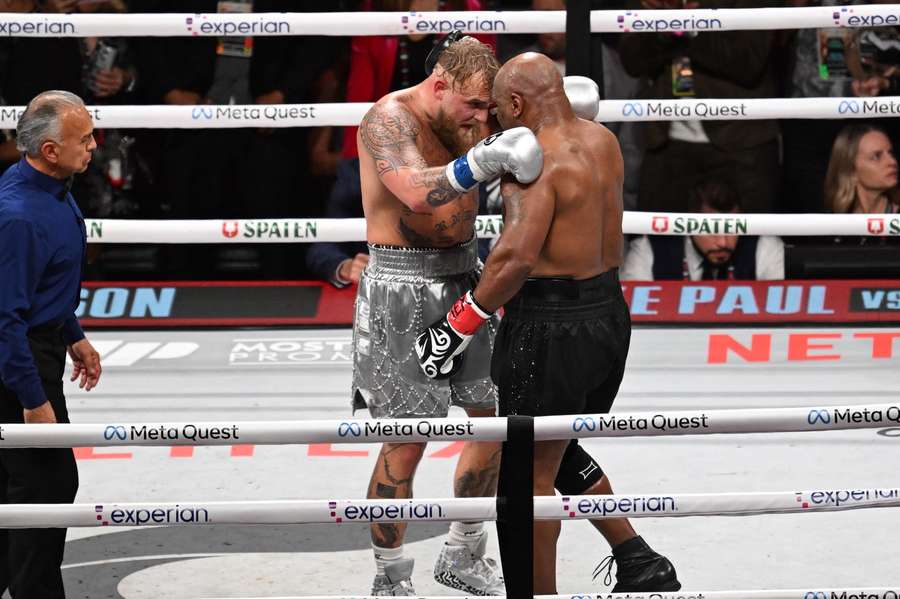  Mike Tyson (in black shorts) and Jake Paul (in silver shorts) hug after 8th round 