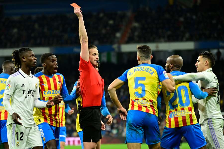 Spanish referee Javier Alberola Rojas presents a red card to Valencia's Brazilian defender Gabriel Paulista