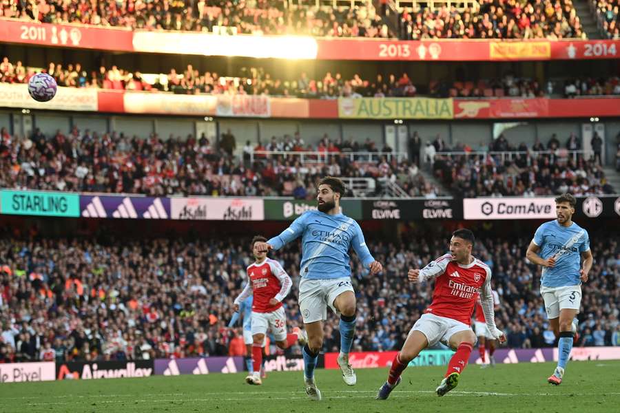 Arsenal's Gabriel Martinelli (2R) chips the ball into the Manchester City net for their late equaliser
