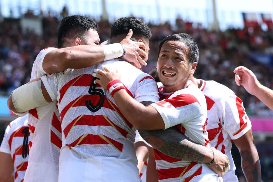 Scrum-half Yutaka Nagare (R) celebrates with teammates after Japan score a try