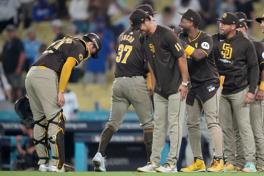 San Diego Padres' Kyle Higashioka, left, bows to pitcher Yu Darvish