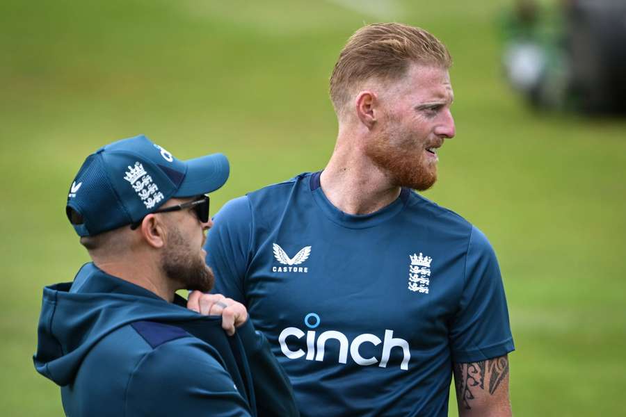 England's captain Ben Stokes (R) speaks with England's head coach Brendon McCullum during a training session