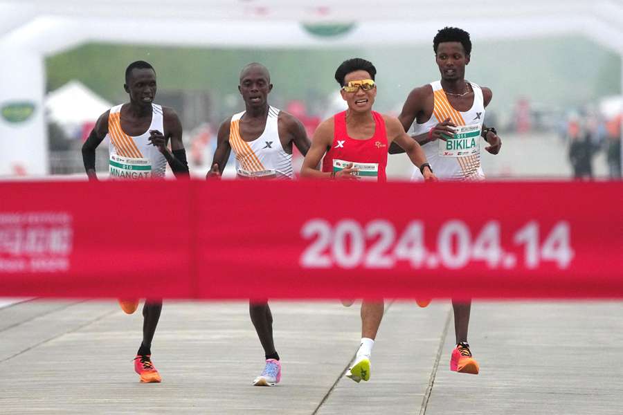 Chinese runner He Jie, Ethiopian Dejene Hailu Bikila and Kenyans Robert Keter and Willy Mnangat 'sprinting' for the finish line