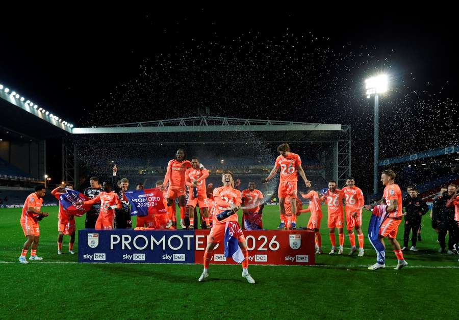 Coventry players celebrate with champagne after winning promotion to the Premier League