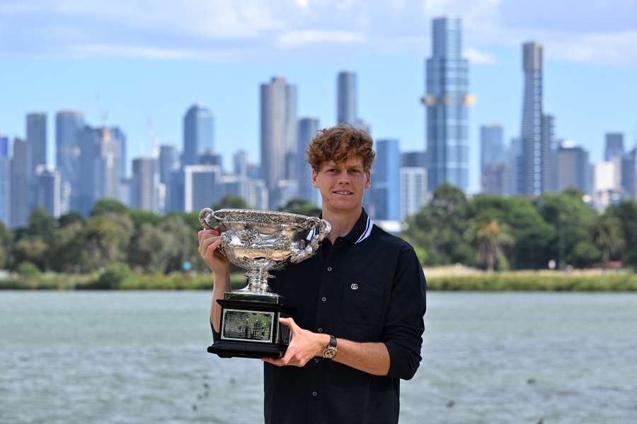Jannik Sinner poses by Melbourne's Yarra River with the 2025 Australian Open trophy.