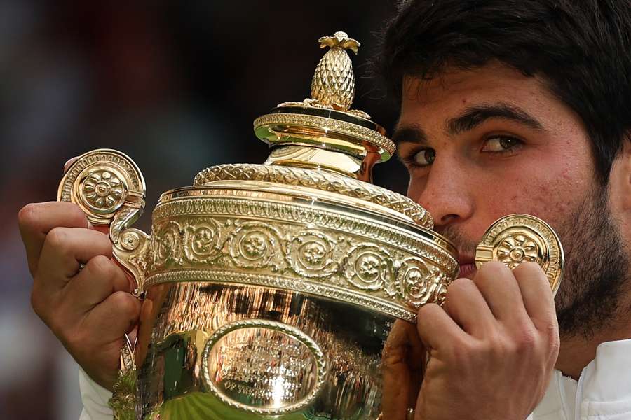 Spain's Carlos Alcaraz kisses the winner's trophy after beating Serbia's Novak Djokovic